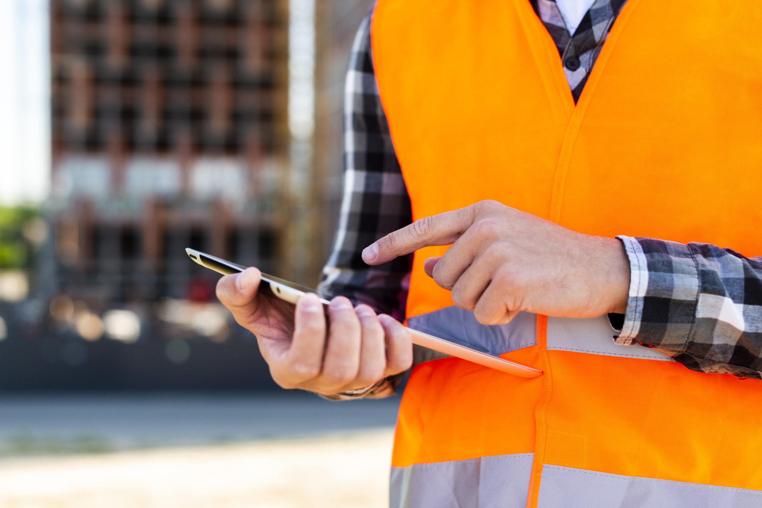 close-up-construction-engineer-using-tablet-min